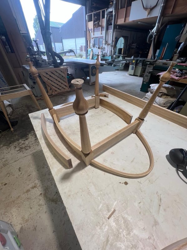 Solid timber chair frame with hand-turned legs under construction in the workshop